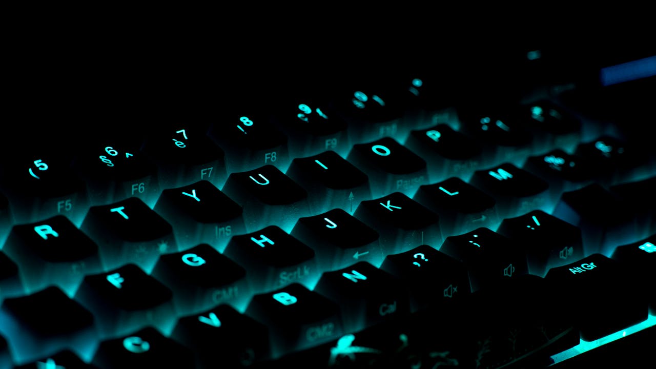 Close-up of a glowing gaming keyboard with blue backlighting in a dark ambiance.